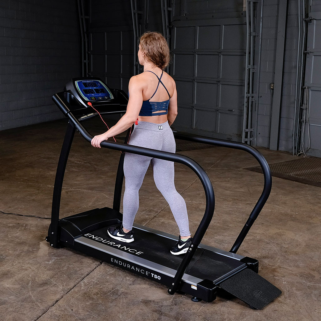 User walking on the Endurance T50 walking treadmill showing the wide rear entry ramp