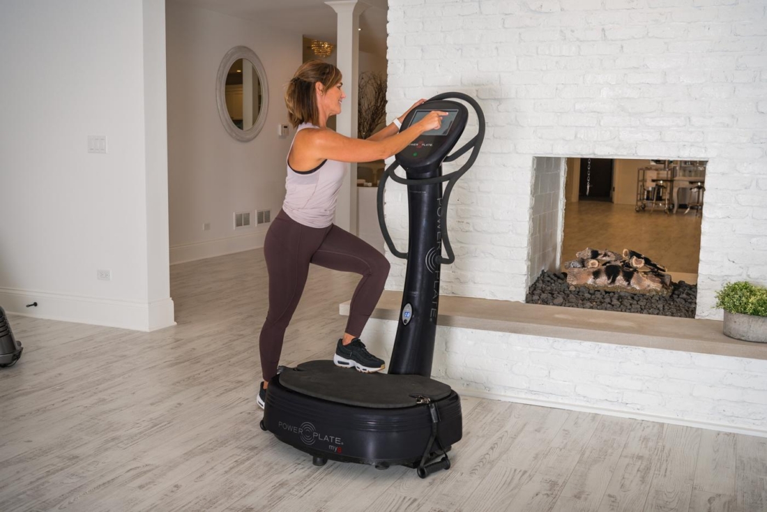 Woman using touchscreen console on Power Plate my8 vibration platform