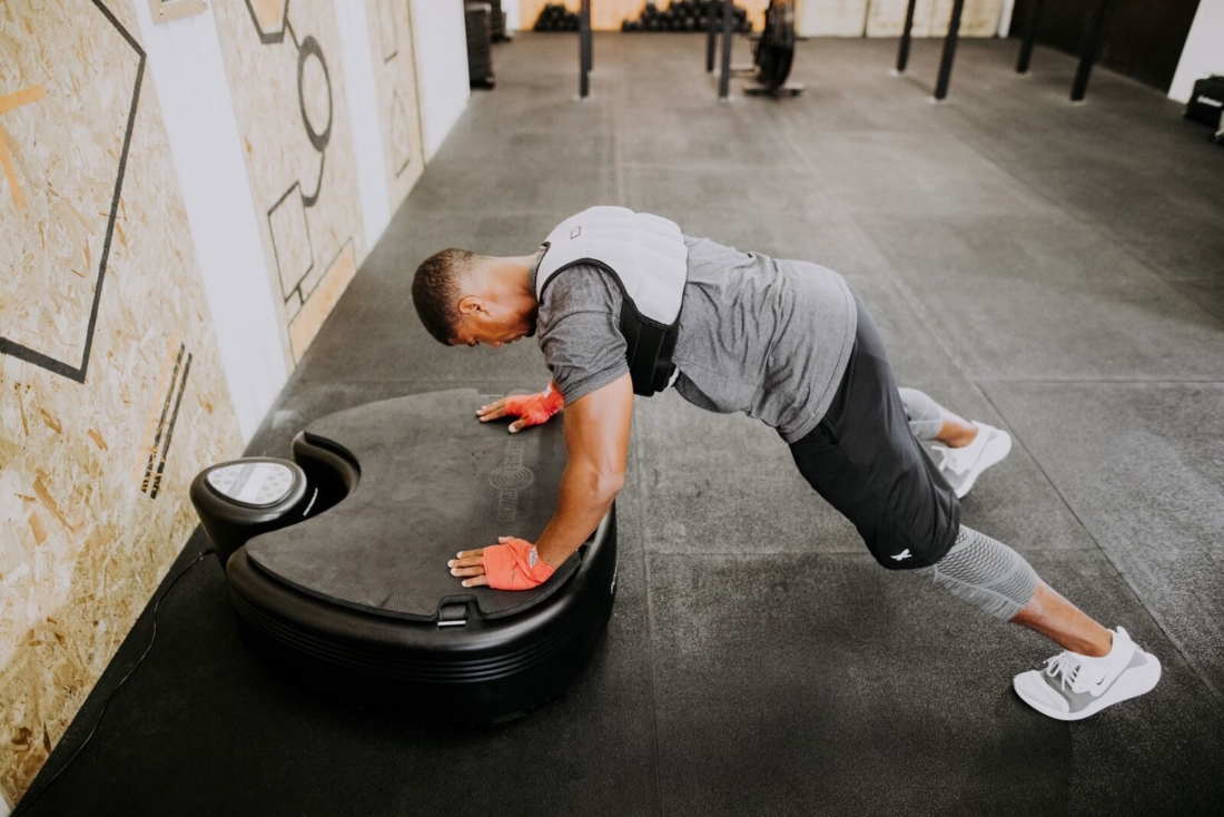 Athlete performing weighted plank on Power Plate pro5HP vibration platform