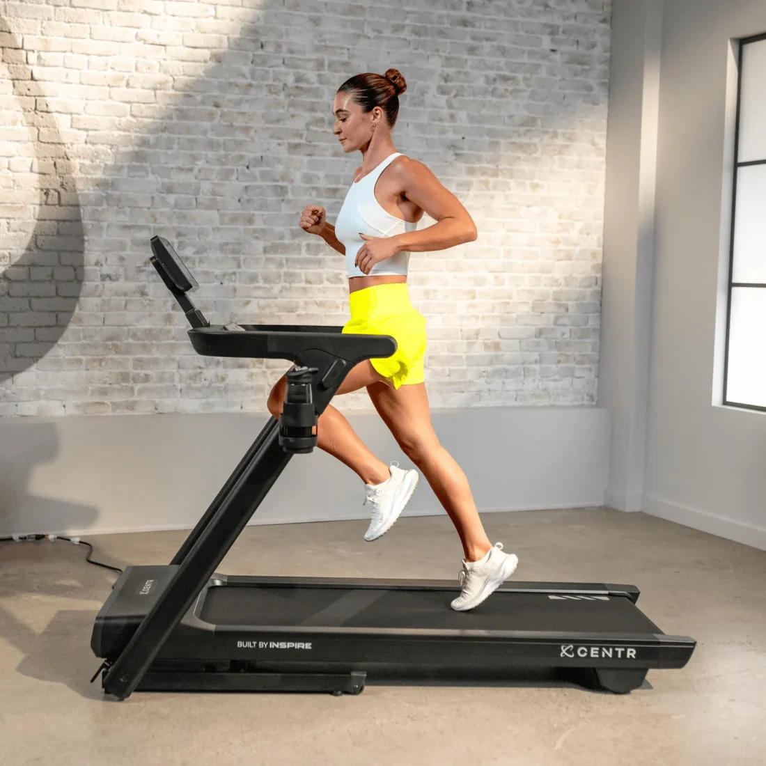Woman running on the Centr Runr-S treadmill