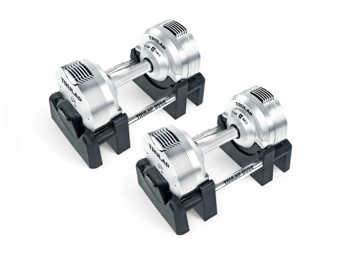 Both Trulap 8552 G4 dumbbells in their nylon docking bases from a three-quarter angle, showing the stacked plates and aluminum handle